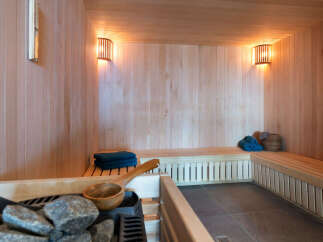 Indulge in tranquility within this exquisite sauna, meticulously crafted with premium wood paneling and featuring ambient lighting.
