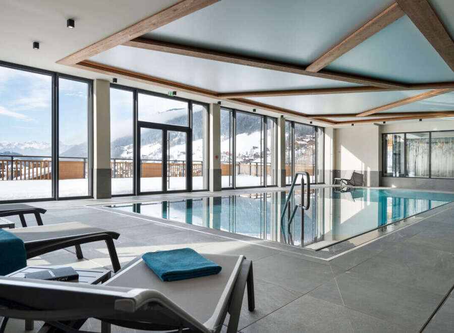 Luxury hotel indoor pool with stunning mountain views.
