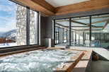 Luxury chalet with stunning mountain views and a spa featuring a hot tub and indoor pool.