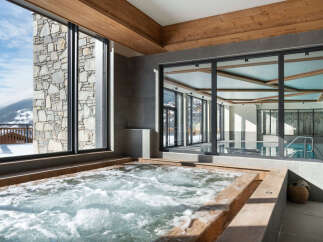 Luxury chalet with stunning mountain views and a spa featuring a hot tub and indoor pool.