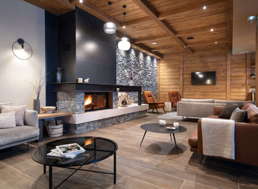 This stunning lodge boasts a spacious living area with a cozy fireplace as the centerpiece, surrounded by comfortable seating and stylish decor.