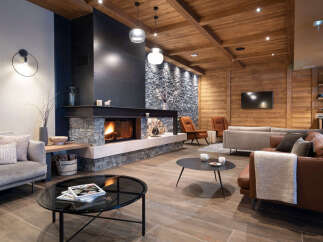 This stunning lodge boasts a spacious living area with a cozy fireplace as the centerpiece, surrounded by comfortable seating and stylish decor.