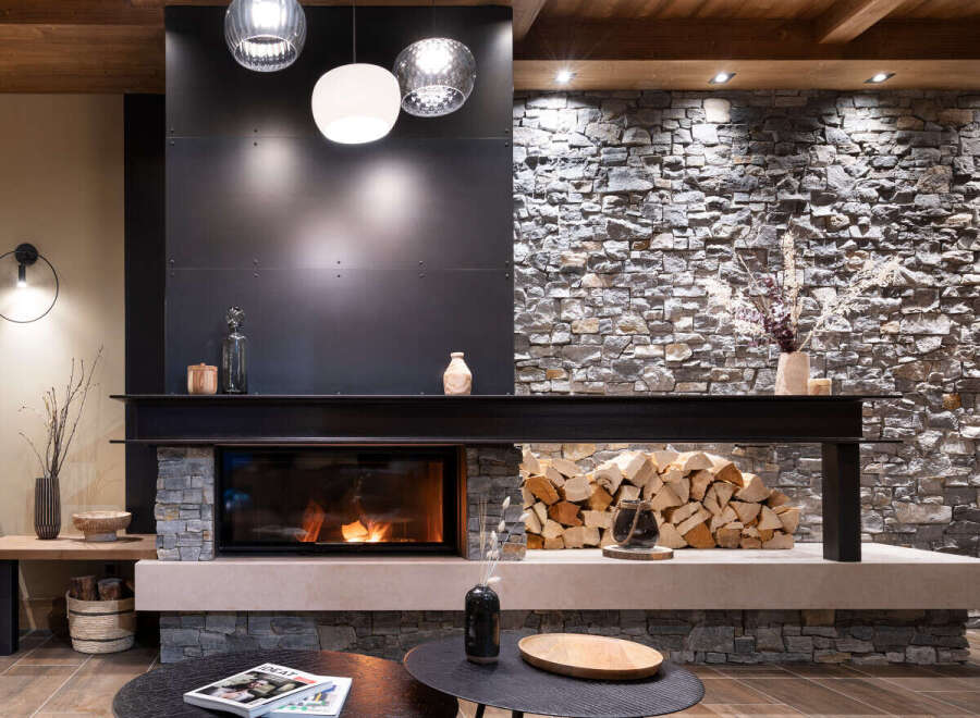 This stunning living room features a modern fireplace with a rustic stone and metal surround, creating a cozy and sophisticated ambiance.