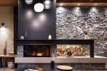 This stunning living room features a modern fireplace with a rustic stone and metal surround, creating a cozy and sophisticated ambiance.