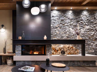 This stunning living room features a modern fireplace with a rustic stone and metal surround, creating a cozy and sophisticated ambiance.