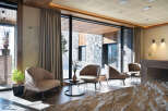 This stunning hotel lobby boasts floor-to-ceiling windows showcasing breathtaking mountain views, creating a bright and airy atmosphere.