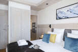 This stunning bedroom boasts a cozy and luxurious atmosphere, featuring a plush bed with soft pillows and a warm, textured throw.