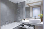 This luxurious bathroom boasts a spacious bathtub and a sleek, modern sink with plenty of counter space.