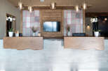 Modern hotel reception with a sleek concrete and wood design.