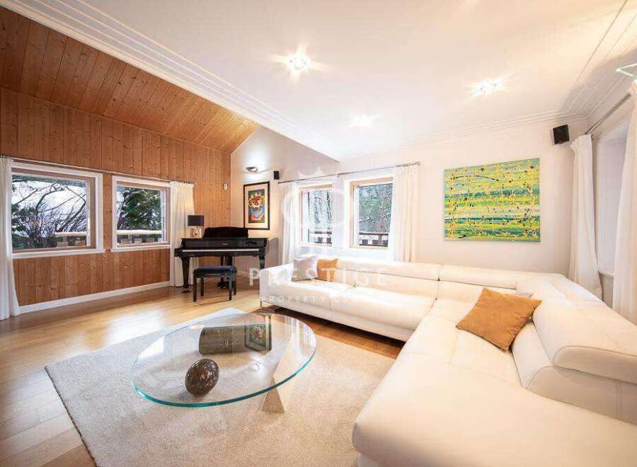 Experience luxury living in this stunning property, featuring a spacious living room with a modern white sofa.