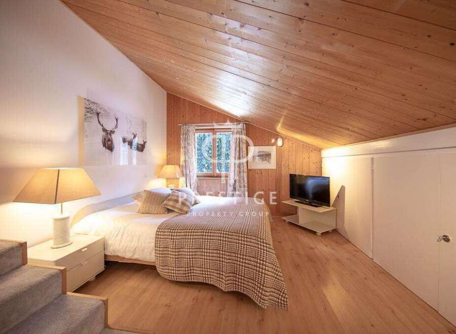 Discover the charm of this cozy bedroom, featuring a unique wooden ceiling and walls that create a warm and inviting atmosphere.