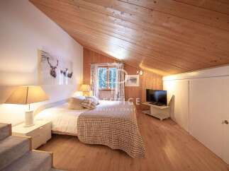 Discover the charm of this cozy bedroom, featuring a unique wooden ceiling and walls that create a warm and inviting atmosphere.