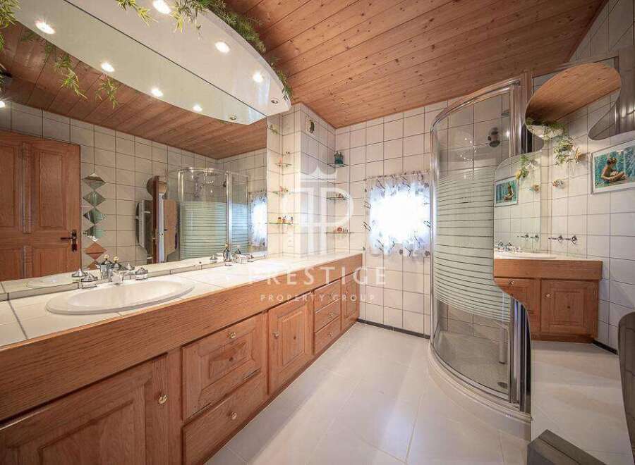 This bathroom boasts a unique design with a wooden ceiling and cabinetry, creating a warm and inviting atmosphere.