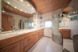This bathroom boasts a unique design with a wooden ceiling and cabinetry, creating a warm and inviting atmosphere.