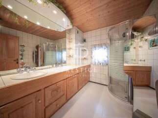 This bathroom boasts a unique design with a wooden ceiling and cabinetry, creating a warm and inviting atmosphere.