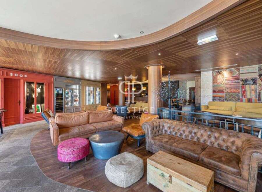 Step into luxury with this stunning property! Featuring a cozy seating area with plush sofas and unique ottomans, perfect for relaxation.