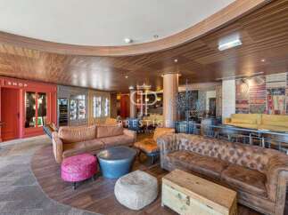 Step into luxury with this stunning property! Featuring a cozy seating area with plush sofas and unique ottomans, perfect for relaxation.