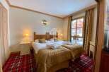 Cozy up in this charming bedroom featuring two comfortable beds, perfect for a relaxing getaway.