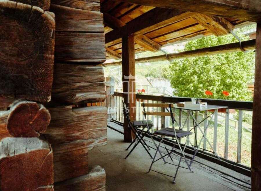 Experience rustic charm in this cozy cabin with a balcony overlooking a serene landscape.