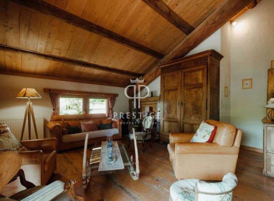 Discover the charm of this rustic property, featuring a warm and inviting living space with exposed wooden beams and a cozy fireplace.