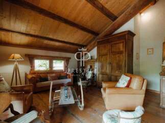 Discover the charm of this rustic property, featuring a warm and inviting living space with exposed wooden beams and a cozy fireplace.