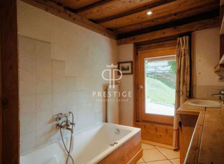 Discover the charm of this property, featuring a cozy bathroom with a wooden bathtub and a rustic wooden ceiling.