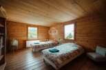 Discover the charm of this cozy bedroom, featuring rustic wooden walls and floors that exude warmth.