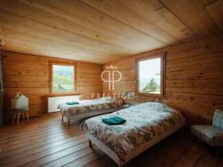 Discover the charm of this cozy bedroom, featuring rustic wooden walls and floors that exude warmth.