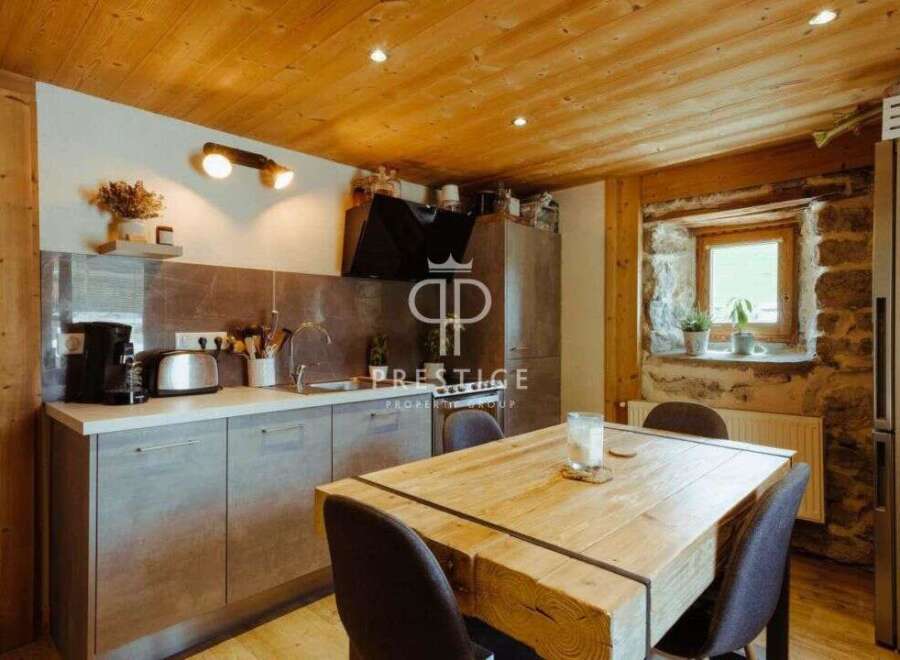 Discover the charm of this rustic kitchen, featuring a beautiful wooden ceiling and a cozy dining area.