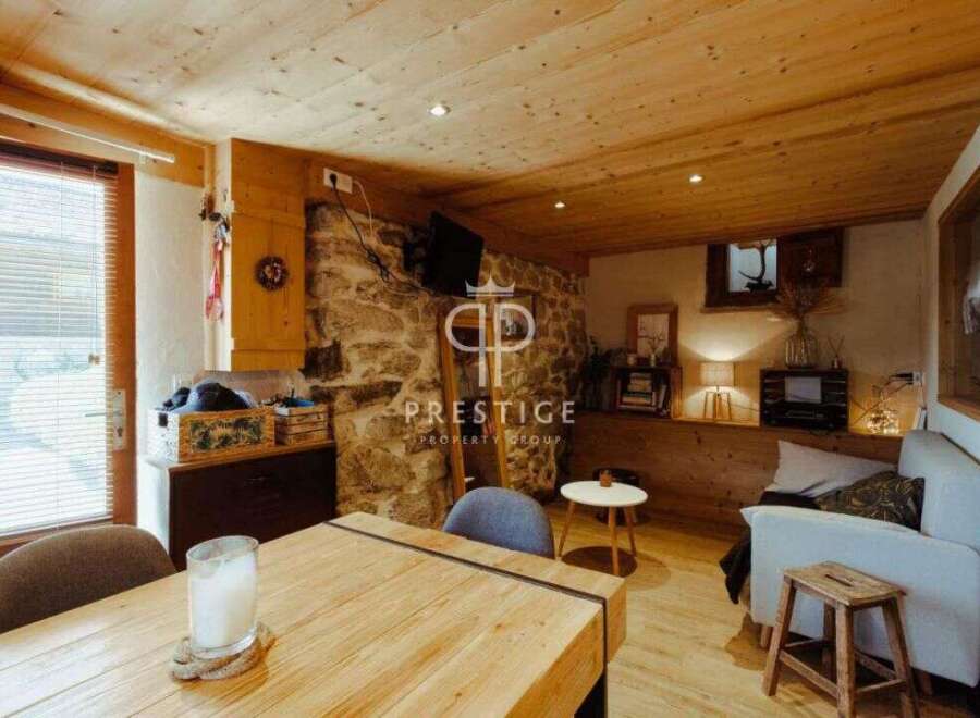 Discover the charm of this cozy property, featuring a rustic stone wall and warm wooden accents throughout.
