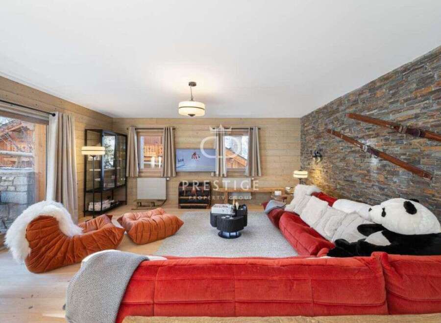 Experience luxury living in this stunning property, featuring a cozy living room with a plush red sofa and a unique panda bear accent.