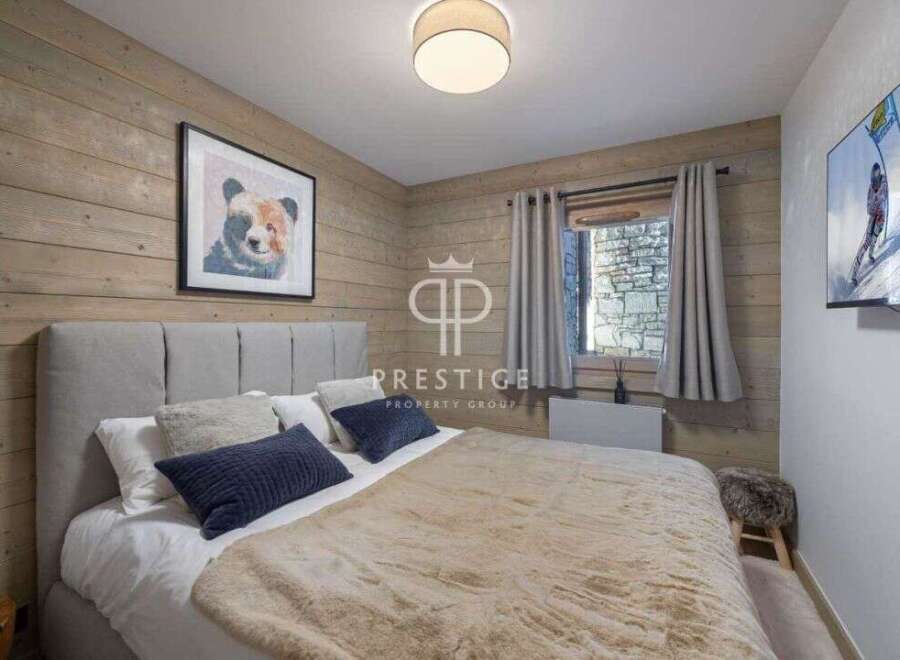Cozy bedroom with rustic wooden walls and a comfortable bed.