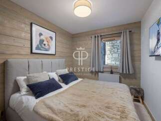 Cozy bedroom with rustic wooden walls and a comfortable bed.