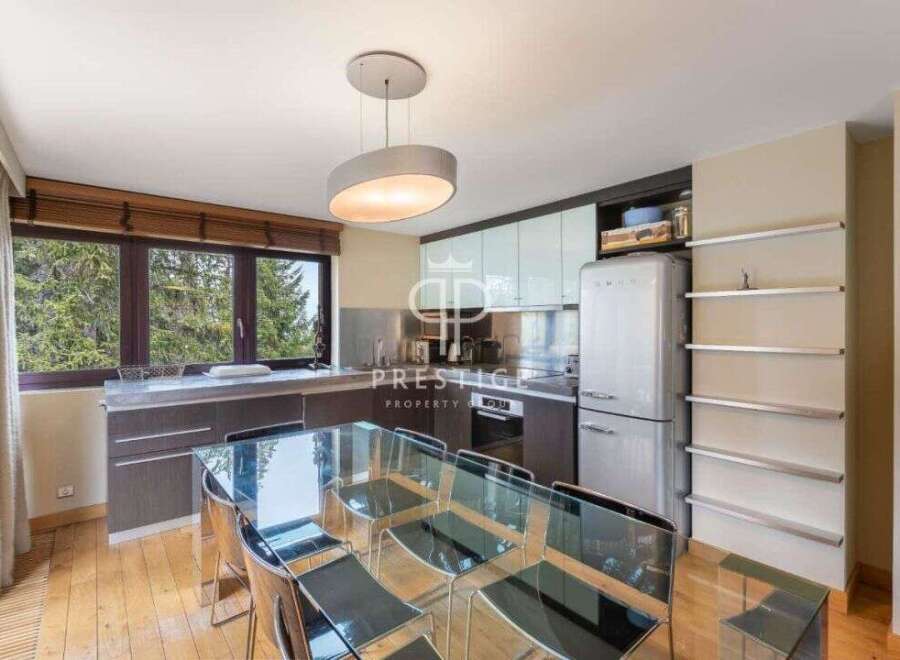 Discover a stunning kitchen with a modern design, featuring a sleek glass dining table and stylish chairs.