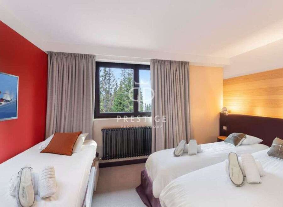 Discover a cozy bedroom with three comfortable beds, perfect for a relaxing stay.
