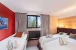 Discover a cozy bedroom with three comfortable beds, perfect for a relaxing stay.