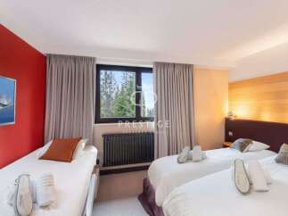 Discover a cozy bedroom with three comfortable beds, perfect for a relaxing stay.