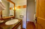 Discover a luxurious bathroom featuring a stylish vanity with a sleek sink and a stunning mirror.