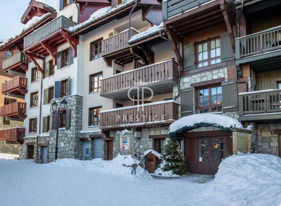Discover the charm of this stunning property, featuring elegant balconies and a picturesque snow-covered facade.