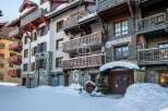 Discover the charm of this stunning property, featuring elegant balconies and a picturesque snow-covered facade.