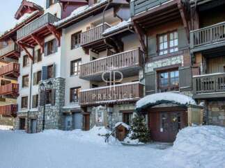 Discover the charm of this stunning property, featuring elegant balconies and a picturesque snow-covered facade.