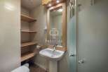 Discover a stylish bathroom featuring a sleek pedestal sink and a modern shower enclosure.