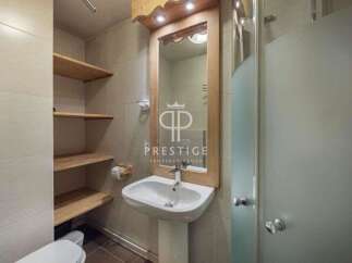 Discover a stylish bathroom featuring a sleek pedestal sink and a modern shower enclosure.