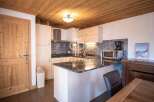 Discover a charming kitchen with a rustic wooden ceiling and cabinetry, creating a warm and inviting atmosphere.