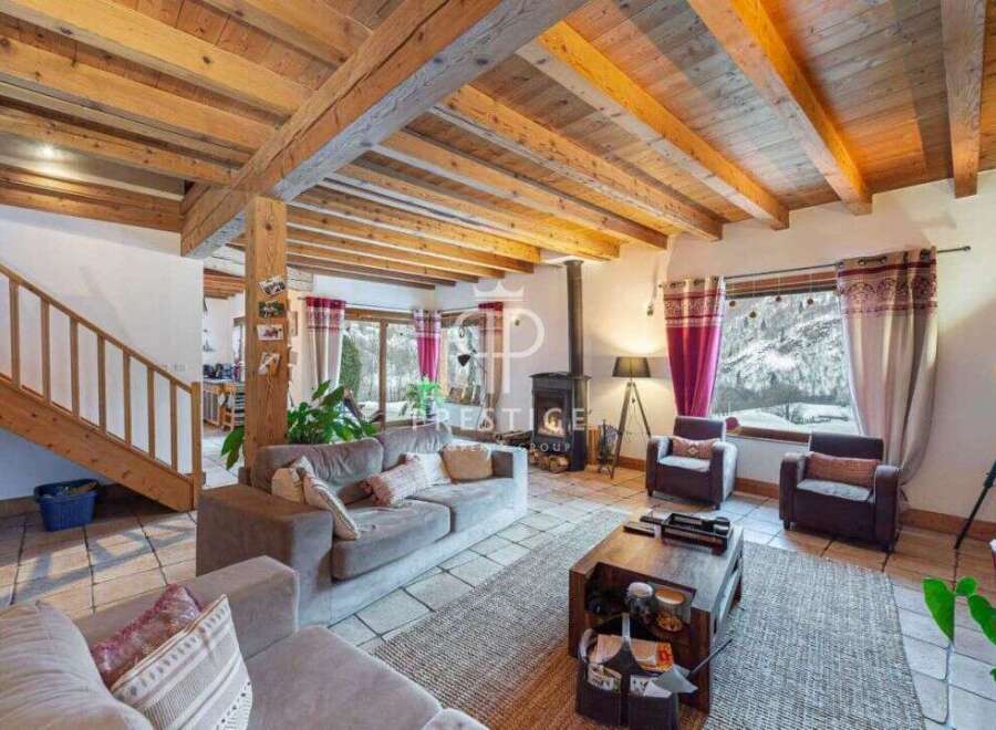 Experience the charm of this stunning property, featuring a cozy living room with a fireplace and exposed wooden beams.
