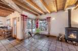 Experience cozy living in this charming chalet, featuring a warm fireplace and exposed wooden beams.