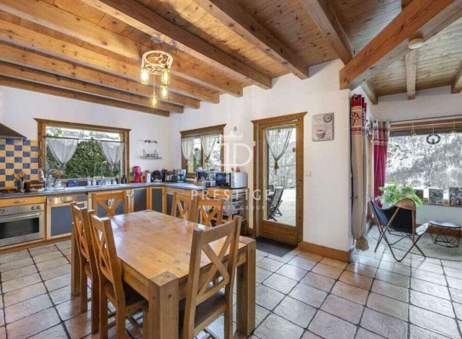 This charming kitchen boasts a rustic design with exposed wooden beams and a cozy dining area.