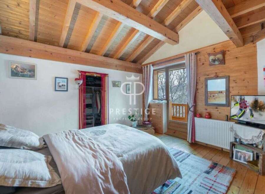 Discover the charm of this cozy bedroom, featuring a rustic wooden ceiling and walls that exude warmth.