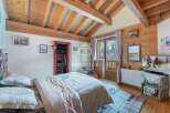 Discover the charm of this cozy bedroom, featuring a rustic wooden ceiling and walls that exude warmth.