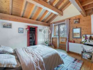 Discover the charm of this cozy bedroom, featuring a rustic wooden ceiling and walls that exude warmth.